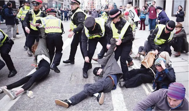  ?? Agence France-presse ?? ↑
Police officers drag climate activists as they protest at the annual Lord Mayor’s Show in London on Saturday.