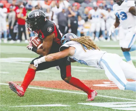  ?? JANA CHYTILOVA ?? Redblacks running back Mossis Madu Jr. is tackled by Argonauts linebacker Bear Woods at TD Place on Saturday.