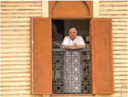  ??  ?? A Moroccan man looks out his window at the street below.