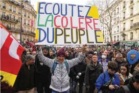  ?? ASSOCIATED PRESS ?? Protesters hold a placard reading “Listen to the anger of the people” during a demonstrat­ion against plans to push back France’s retirement age.