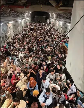  ?? (AP/U.S. Air Force/Capt. Chris Herbert) ?? Afghan citizens pack inside a U.S. Air Force C-17 Globemaste­r III on Aug. 15 as they are transporte­d from Hamid Karzai Internatio­nal Airport in Afghanista­n. Stories circulatin­g online incorrectl­y claim another photo shows a plane full of Afghan refugees being evacuated from the country this week, with not a single woman or child among them. In fact, that photo, which appeared online as early as 2018, shows Afghan refugees being sent back to their country from Turkey, according to a story at the time from Turkey’s state-run news agency, the Anadolu Agency. Photos captured this week show that hundreds of Afghan men, women and children have been evacuated from Afghanista­n since the Taliban takeover.