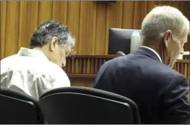  ?? The Maui News / LILA FUJIMOTO photo ?? Murder suspect Jesse Hueu (left) sits with his attorney, Richard Gronna, during his 2nd Circuit Court trial Thursday. Hueu has pleaded not guilty to second-degree murder in the Dec. 11, 2014, killing of 56-year-old Derrick Kualaau, who was found beaten at his shack at Maliko Gulch.