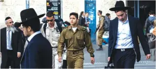  ?? (Olivier Fitoussi/Flash90) ?? ULTRA-ORTHODOX men walk along side an IDF soldier in Jerusalem last year.