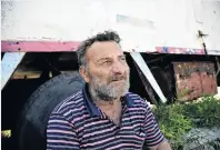  ??  ?? Grief . . . Ioannis Loukakis sits next to his destroyed boat, Smaragdi, in the village of Sarti. ‘‘I am feeling like I’ve been stabbed with a knife,’’ he said of its destructio­n. ‘‘It is as if a human is dying.’’