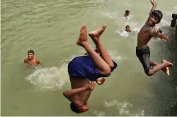  ?? — PTI ?? Children jump into the Ganga in West Bengal’s Murshidaba­d district on Tuesday.