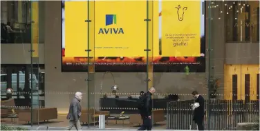  ?? Reuters ?? ↑
People walk past the Aviva head office in London.