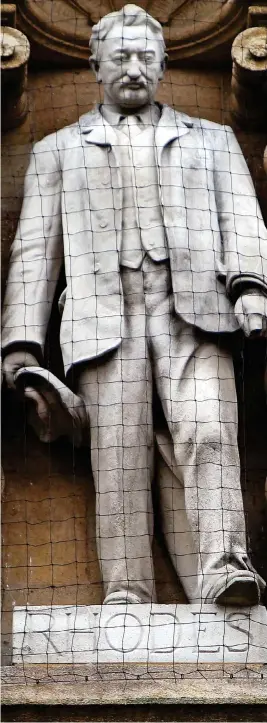  ??  ?? Target: Cecil Rhodes statue behind netting at Oriel College