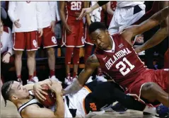  ?? Sue Ogrocki / AP ?? Oklahoma State’s Jeffrey Carroll (left) grabs onto a loose ball in front of Oklahoma’s Kristian Doolittle during overtime of Saturday’s game in Stillwater, Okla. Oklahoma State won 83-81.