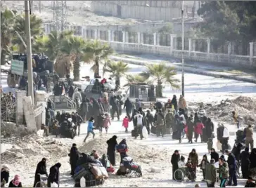  ?? GEORGE OURFALIAN/AFP ?? Syrian civilians arrive at a checkpoint manned by pro-government forces, at the al-Hawoz street roundabout, after leaving Aleppo’s eastern neighbourh­oods, on Saturday.