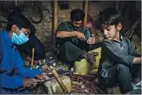  ??  ?? IZZATULLAH Neamat carves a block of wood into a rubab as his assistants work. He is planning to f lee to Pakistan.