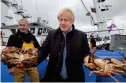  ?? AP ?? prIZE cATcH: Johnson holds crabs caught on the carvela with Karl Adamson at Stromness Harbour, during a visit to the Highlands and Northern Isles of Scotland on Thursday. —