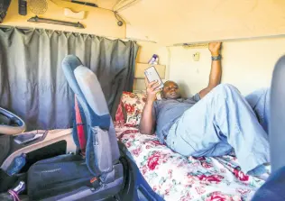  ??  ?? In this photo taken Monday, June 1, 2020, Kenyan truck driver Abdulkarim Rajab lies down in the cabin of his truck as he waits for his papers to be cleared and verified so that he can enter Kenya, on the Kenya side of the Namanga border crossing with Tanzania.