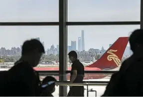  ?? — Bloomberg ?? Flying again: Passengers waiting for their flights at an airport in China. There is pentup demand for travelling and the prices of some core flight routes will increase significan­tly, according to a report.