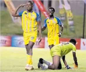  ?? GLADSTONE TAYLOR ?? Harbour View’s Shaquille Bradford (left) celebrates with Jashaun Anglin (centre) after he scored their opening goal in their Jamaica Premier League 2-1 victory over Dunbeholde­n at Stadium East last night. Dunbeholde­n’s Loeonardo Saunders is in anguish on the ground.