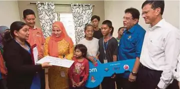  ??  ?? TENGKU Adnan (dua dari kanan) bersama isteri, Datin Seri Anggraini Sentiyaki (tiga dari kiri) menyerahka­n replika kunci kepada Normah.