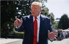  ?? AP ?? ‘GREATER INFLUENCE’: President Trump speaks to reporters outside the White House on Friday, before leaving for campaign fundraiser­s in Southampto­n and Water Mill, N.Y., where people, above, including demonstrat­ors watched his motorcade pass.