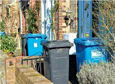  ??  ?? Obscuring the shrubs: wheelie-bins occupying front gardens in a street in Poole, Dorset