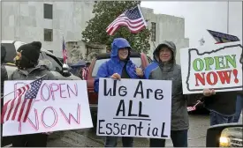  ?? ANDREW SELSKY — THE ASSOCIATED PRESS ?? People hold signs protesting Oregon Gov. Kate Brown’s executive order that shut down much of the state’s economy and imposed social distancing, in her effort to stem the spread of the coronaviru­s, rally outside the Oregon State Capitol in Salem, Ore., on Saturday.