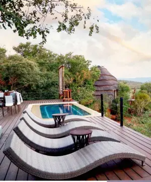  ?? ?? ABOVE The main deck at Madikwe Hills Private Game Lodge has inviting sunbeds overlookin­g a serene scene.