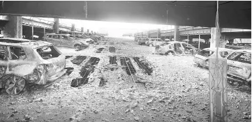  ??  ?? Burnt cars are seen in what remains of the multi-storey car park, where a large fire destroyed many cars on Sunday, in King’s Dock, Liverpool. — Reuters photo