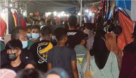  ?? DANIAL SAAD PIX BY ?? People packed in between stalls at the Kubang Menerong bazaar in Tasek Gelugor on Saturday. (Right) Police issuing a compound to the bazaar organiser.