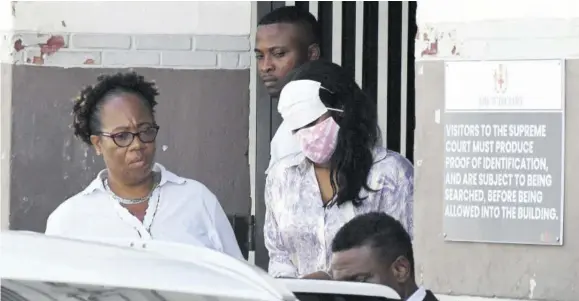  ?? (Photo: Naphtali Junior) ?? US Navy Culinary Specialist Seaman Leoda Bradshaw (right) is seen leaving the Supreme Court, downtown Kingston with her face covered by two masks on October 13, 2023 after she was charged with murder in the deaths of Phillip Pauwell’s 10-month-old daughter and her mother.