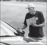  ?? Arkansas Democrat-Gazette/BENJAMIN KRAIN ?? A motorist slows to give money to a panhandler Wednesday at the Main Street exit off Interstate 630 in Little Rock.