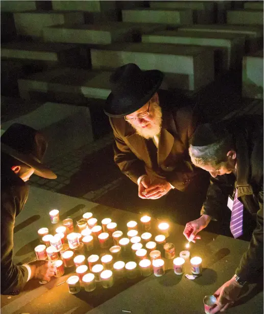  ?? (Reuters) ?? PARTICIPAN­TS OF the Conference of European Rabbis light candles as they commemorat­e Kristallna­cht at the Holocaust Memorial in Berlin, in 2013.