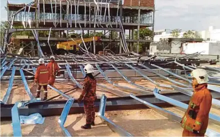  ?? PIC COURTESY OF FIRE AND RESCUE DEPARTMENT ?? Fire and Rescue Department personnel inspecting the scene of the accident in Juru yesterday.