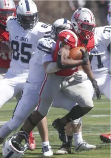  ?? NiColAuS CzArneCki / herAld StAFF ?? RUNNING WITH IT: Catholic Memorial’s Datrell Jones is tackled by St. John Prep’s Ryan Grenier on Saturday.