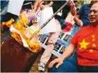  ??  ?? 示威者抗議川普的貿易­戰，並焚燒川普像片。 (美聯社)