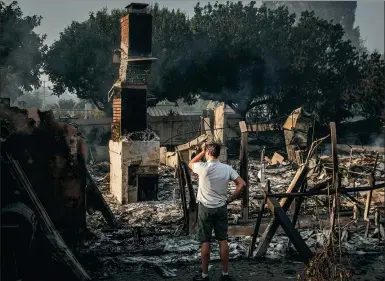  ?? LA TIMES VIA GETTY IMAGES ?? A man looks at the ruins of his home destroyed by wildfire, in Goleta, California, on Saturday.