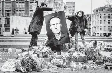  ?? REMKO DE WAAL UPI ?? People gather in Amsterdam this weekend to hold a vigil for Russian opposition leader Alexei Navalny. On Thursday, Navalny’s mother said authoritie­s finally had allowed her to see her son’s body, and a family spokesman said Saturday that his body had been turned over to the family for burial.
