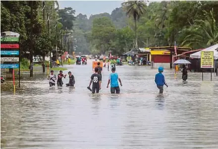  ?? KORI NSTP PIC BY GHAZALI ?? People wading through floodwater­s in Kampung Baru Kemasik, Kemaman, yesterday.