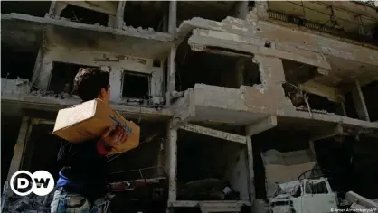  ??  ?? Un niño observa apartament­os destruidos por las fuerzas del régimen de Assad en Ghuta, oriente de Siria.