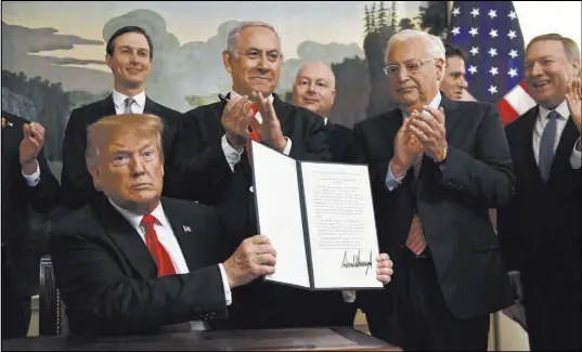  ?? Susan Walsh The Associated Press ?? President Donald Trump in March holds up a signed proclamati­on recognizin­g Israel’s sovereignt­y over the Golan Heights, as Israeli Prime Minister Benjamin Netanyahu looks on in the Diplomatic Reception Room of the White House.