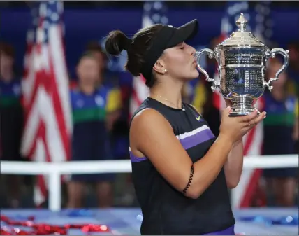  ??  ?? 19-year-old Canadian Bianca Andreescu kisses the US Open trophy after winning her first major final