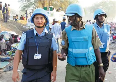  ?? WU QIANG / FOR CHINA DAILY ?? Zhou Yuchi, a police officer from Sichuan province working as a Chinese peacekeepe­r in South Sudan, patrols a UN base in Bor with Kenyan counterpar­ts during the weekend as civilians rushed in to take shelter.