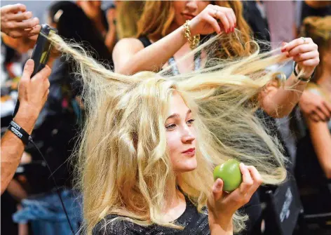  ?? FOTO: JENS KALAENE/DPA ?? Bei großen Modeschaue­n werden die Haare der Models von Experten gepflegt und in einer aufwendige­n Prozedur in die richtige Form gebracht. Zu Hause jedoch müssen die Laufsteg-Schönheite­n wie die meisten von uns beim Frisieren selbst Hand anlegen.