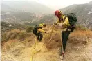  ?? Photograph: David Crane/AP ?? Members of the Mormon Lake Hotshots from Arizona lay hose line down rugged terrain off Highway 39 in front of the Bobcat fire.