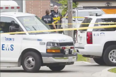  ?? CP PHOTO ?? Police stand in front of a house in Scarboroug­h, Ont., after three people were killed in a crossbow incident.