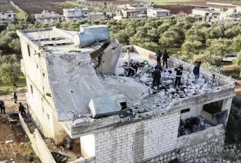  ?? GHAITH ALSAYED AP ?? People inspect a destroyed house Thursday after a raid by the U.S. military in Idlib province, Syria. The target of the raid, Abu Ibrahim al-Hashimi al-Qurayshi, died in an explosion he set off himself, U.S. officials said.