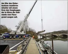  ?? ?? Am Ufer des Elsterbeck­ens montieren Arbeiter mit einem Kran den Saugbagger, der in Kürze die Sedimente vom Flussgrund saugen soll.