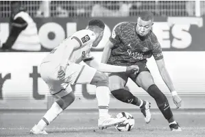  ?? — Gambar AFP ?? FOKUS: Mbappe (kanan) mengawal bola pada perlawanan Ligue 1 Perancis di antara Auxerre dan Paris Saint-Germain di Stade de l’Abbe-Deschamps di Auxerre, kelmarin.