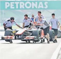  ??  ?? Pit crew of the Mercedes F1 team push the car of Lewis Hamilton of Britain at the Sepang Internatio­nal Circuit, in this March 22, 2012 file photo. — AFP photo