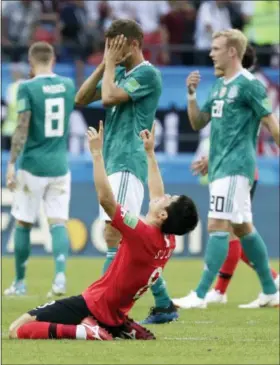  ?? LEE JIN-MAN — THE ASSOCIATED PRESS ?? Germany’s players walk off the pitch as South Korea’s Ju Se-jong, front, celebrates after South Korea’s 2-0 win in Kazan, Russia on Wednesday.