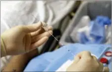  ?? PATRICK SEMANSKY — THE ASSOCIATED PRESS ?? In this photo anesthesio­logist Dr. Ron Samet performs an ultrasound-guided nerve block at the University of Maryland Medical Center, preparing a catheter that will deliver a numbing drug to nerves responsibl­e for a patient’s arm pain. Nerve blocks...