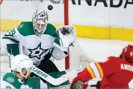  ?? The Canadian Press ?? Dallas Stars goaltender Jake Oettinger faces a shot from Calgary Flames defenceman Rasmus Andersson during second-period NHL playoff action on Wednesday in Calgary.