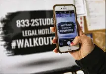  ?? CURTIS COMPTON / CCOMPTON@AJC.COM ?? Decatur High School student Olivia Poth-nebel snaps a photo of the legal hotline to send out to participan­ts while organizers train students for the National Student Walk Out on Monday in Atlanta.