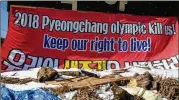  ?? CARL COURT / GETTY IMAGES ?? A banner protesting against the closure of ski slopes in Phoenix Park during the Pyeongchan­g Winter Olympics hangs from the side of a shop Tuesday in South Korea.